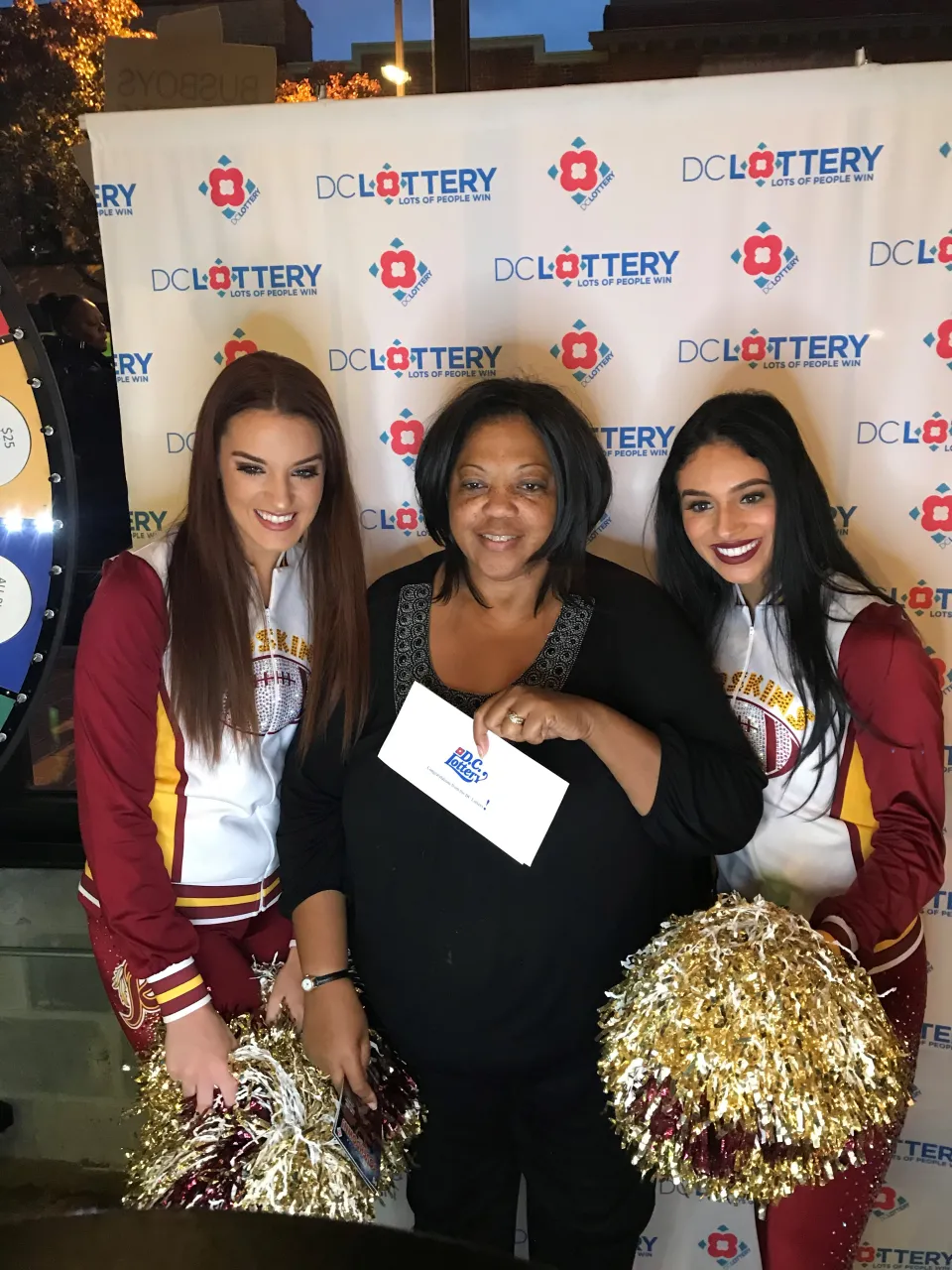 Player holding her prize with cheerleaders